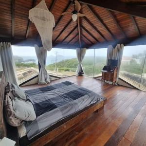 1 dormitorio con 1 cama en una habitación con ventanas en Villa Ferradura, en Búzios