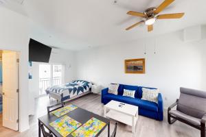 a living room with a blue couch and a bed at Ocean Isles 50 in Marathon