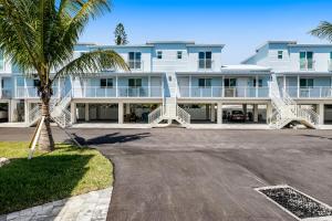 a large white building with a palm tree in front of it at Ocean Isles 50 in Marathon