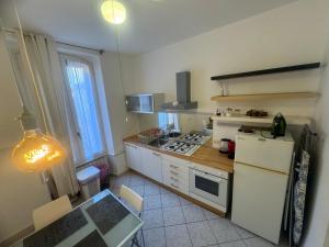 Elle comprend une petite cuisine équipée d'un réfrigérateur blanc et d'une table. dans l'établissement Sunny House, à Milan