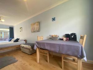 a room with a table and a bed with a purple table cloth at Bluebelle in Bray