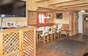 une salle à manger avec une table et une télévision dans une cabane en rondins dans l'établissement Stunning Home In Breitenfeld With Sauna, à Breitenfeld an der Rittschein