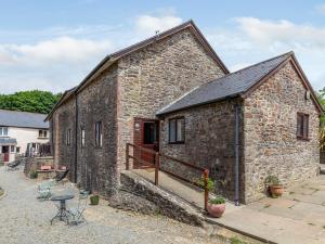 an old stone building with a balcony in front of it at 3 Bed in South Molton 78305 in Kings Nympton