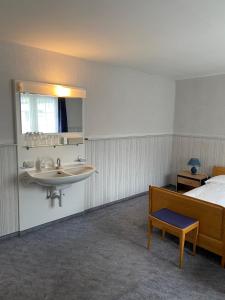 una camera d'albergo con lavandino e letto di Hotel National a Wattwil