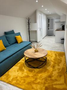 uma sala de estar com um sofá azul e um tapete amarelo em Studio apartman Cuprija em Cazin