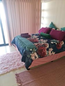 um quarto com uma cama com colcha floral em 17 Santana Pebbles Penthouse em La Mercy