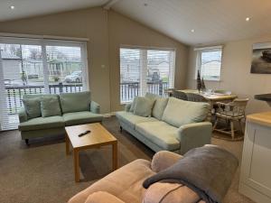 a living room with two couches and a table at Lakeview Lodge in Chichester