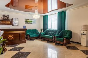 uma sala de espera com cadeiras de couro verde e um pódio em Villa Victoria em Bukovel