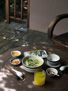 a table with bowls and plates of food on it at TOKI Retreat Vân Long in Ninh Binh