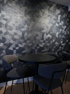 a room with two tables and chairs and a patterned wall at Amsterdam Lake Hotel in Badhoevedorp