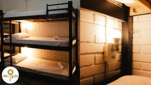 a room with two bunk beds in a brick wall at Golden Garden Hostel in Ubatuba