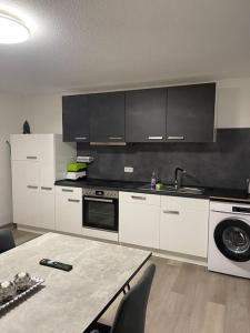a kitchen with white appliances and a table with chairs at Monteurwohnung Kassel, 4 Personen in Niestetal