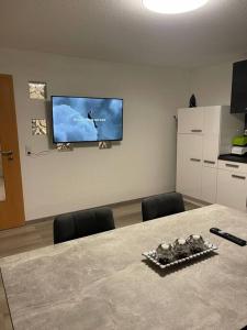 a room with a table and a tv on a wall at Monteurwohnung Kassel, 4 Personen in Niestetal