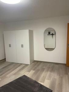 an empty room with white cabinets and a mirror at Monteurwohnung Kassel, 4 Personen in Niestetal