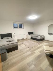 a white room with a bed and a couch at Monteurwohnung Kassel, 4 Personen in Niestetal