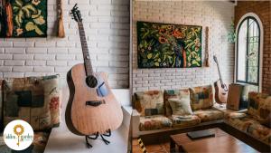 sala de estar con guitarra y sofá en Golden Garden Hostel en Ubatuba