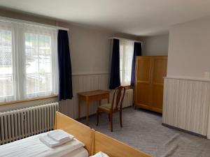 1 dormitorio con 1 cama, 1 mesa y 1 silla en Hotel National, en Wattwil
