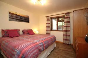 a bedroom with a bed with red pillows and a window at Boardman's Lodge in Peterborough