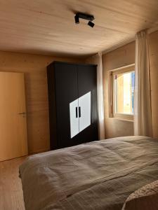 Un dormitorio con una cama grande y una ventana en Mondholz Ferienwohnung, en Andermatt