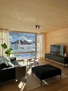 a living room with a couch and a television at Mondholz Ferienwohnung in Andermatt