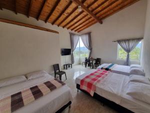 sypialnia z 2 łóżkami i jadalnią w obiekcie HOSPEDAJE VILLA SAMARA w mieście Guatapé