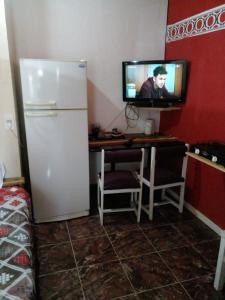 a kitchen with a refrigerator and a tv in a room at Apart Alcázar in Trelew +11 photos