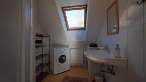 a bathroom with a washing machine and a sink at Jutta´s Ferientraum in Kottes