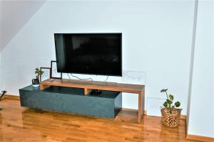 a flat screen tv sitting on a stand in a living room at Špansko view -Comfy apartment in Zagreb