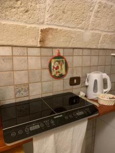 a kitchen counter with a stove top and a tea kettle at Casa Dante - Holiday House in Fasano +9 photos