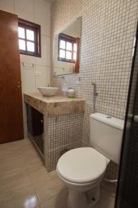 uma casa de banho com um WC branco e um lavatório. em Casa de campo c lazer completo e WiFi Bezerro PE em Bezerros