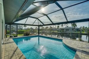 uma grande piscina com um grande tecto de vidro em Canalfront Cape Coral Escape with Lanai and Pool! em Cape Coral