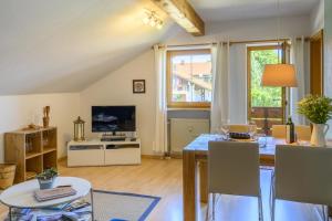 a kitchen and living room with a table and chairs at Ferienwohnung Lampl 7 in Bad Kohlgrub