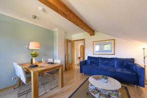 ein Wohnzimmer mit einem blauen Sofa und einem Tisch in der Unterkunft Ferienwohnung Lampl 7 in Bad Kohlgrub