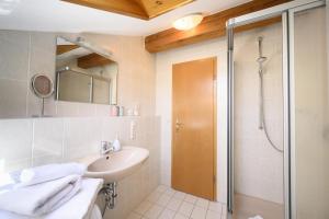 La salle de bains est pourvue d'un lavabo et d'une douche. dans l'établissement Ferienwohnung Lampl 7, à Bad Kohlgrub