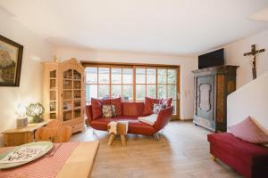 a living room with a red couch and a table at Ferienhaus Alpenliebe in Grainau in Grainau