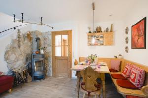 a living room with a table and a stone fireplace at Ferienhaus Alpenliebe in Grainau in Grainau