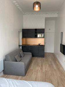 a living room with a couch and a kitchen at Studio Montorgueil in Paris