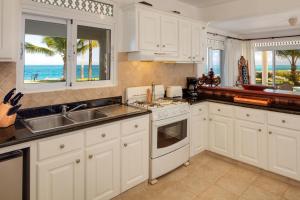 cocina con armarios blancos y vistas al océano en Luxury Oceanfront Villa with Amazing Views, en Sosúa