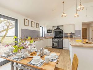 a kitchen with a wooden table with plates and cups at 4 Bed in High Bickington 86720 in High Bickington