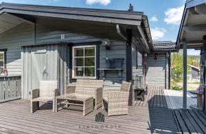 a patio with wicker chairs and a table on a house at Cozy cottage in Vemdalen close to the ski slopes in Vemdalen