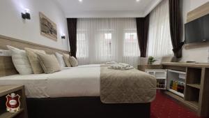 Habitación de hotel con cama grande y TV en Hotel Nacional Free Parking en Sarajevo