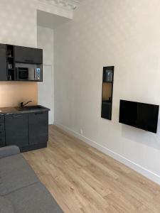ein Wohnzimmer mit einem Flachbild-TV an der Wand in der Unterkunft Studio Montorgueil in Paris