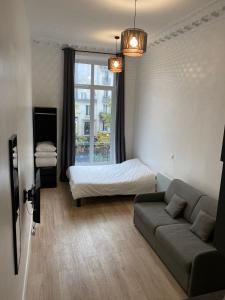 ein Wohnzimmer mit einem Sofa und einem Bett in der Unterkunft Studio Montorgueil in Paris