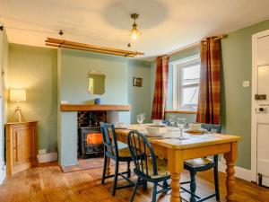 a dining room with a table and chairs and a fireplace at 2 Bed in Egremont 87227 in Egremont