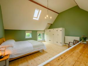 a bedroom with a bed and a green wall at 2 Bed in Egremont 87227 in Egremont