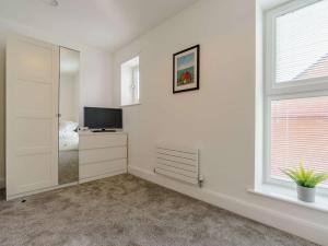 una camera da letto bianca con televisore e finestra di 4 Bed in Whitley Bay 87396 a Whitley Bay