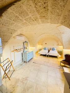 1 dormitorio con 2 camas en una habitación con techo de piedra en Al Palazzotto, en Fasano