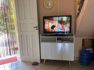 a flat screen tv sitting on top of a white entertainment center at Da Judite in Santa Cruz Cabrália