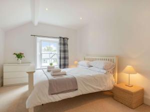 um quarto branco com uma cama grande e uma janela em 4 Bed in Keswick 87567 em Keswick