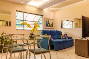 sala de estar con sofá azul y mesa en Apto 15 min das Aguas Termais em Araxa MG, en Araxá